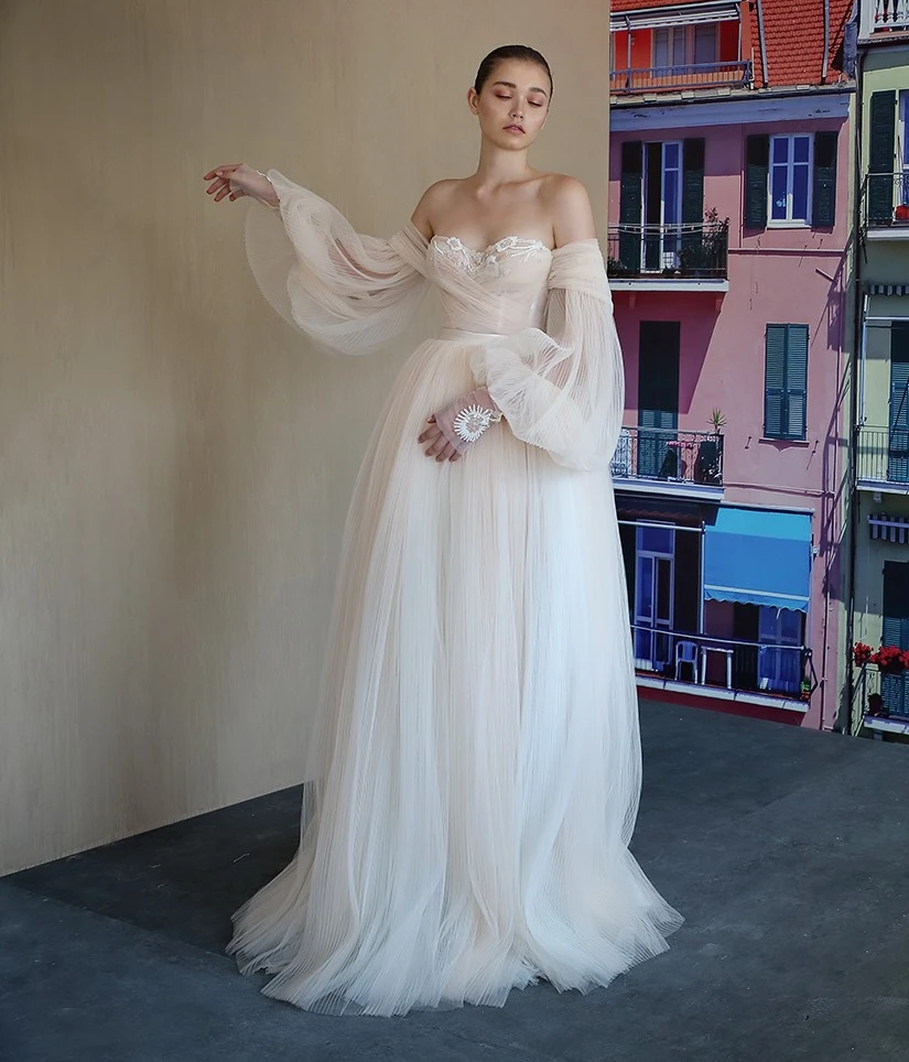 A model wears the Galia Lahav Bellina dress in front of a window