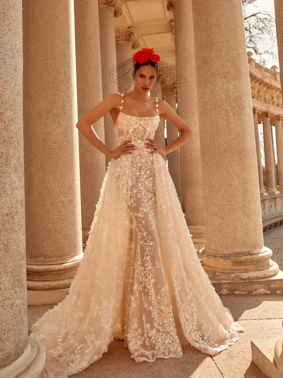 A model wears the Galia Lahav Catalina dress near stone pillars