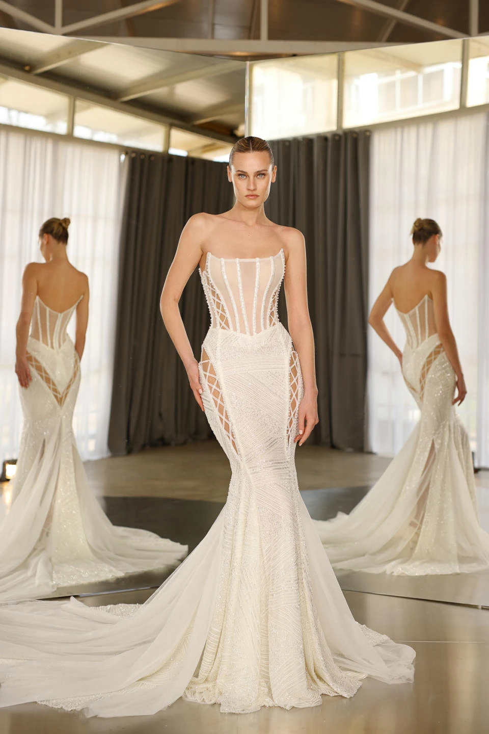 A model wears the Galia Lahav Diem dress in front of a mirror