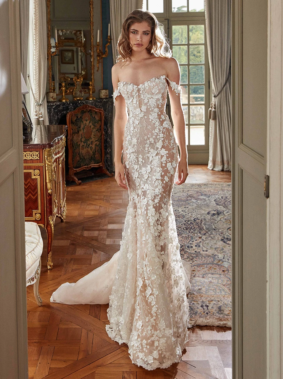 A model wears the Galia Lahav Maya dress while standing near a doorway