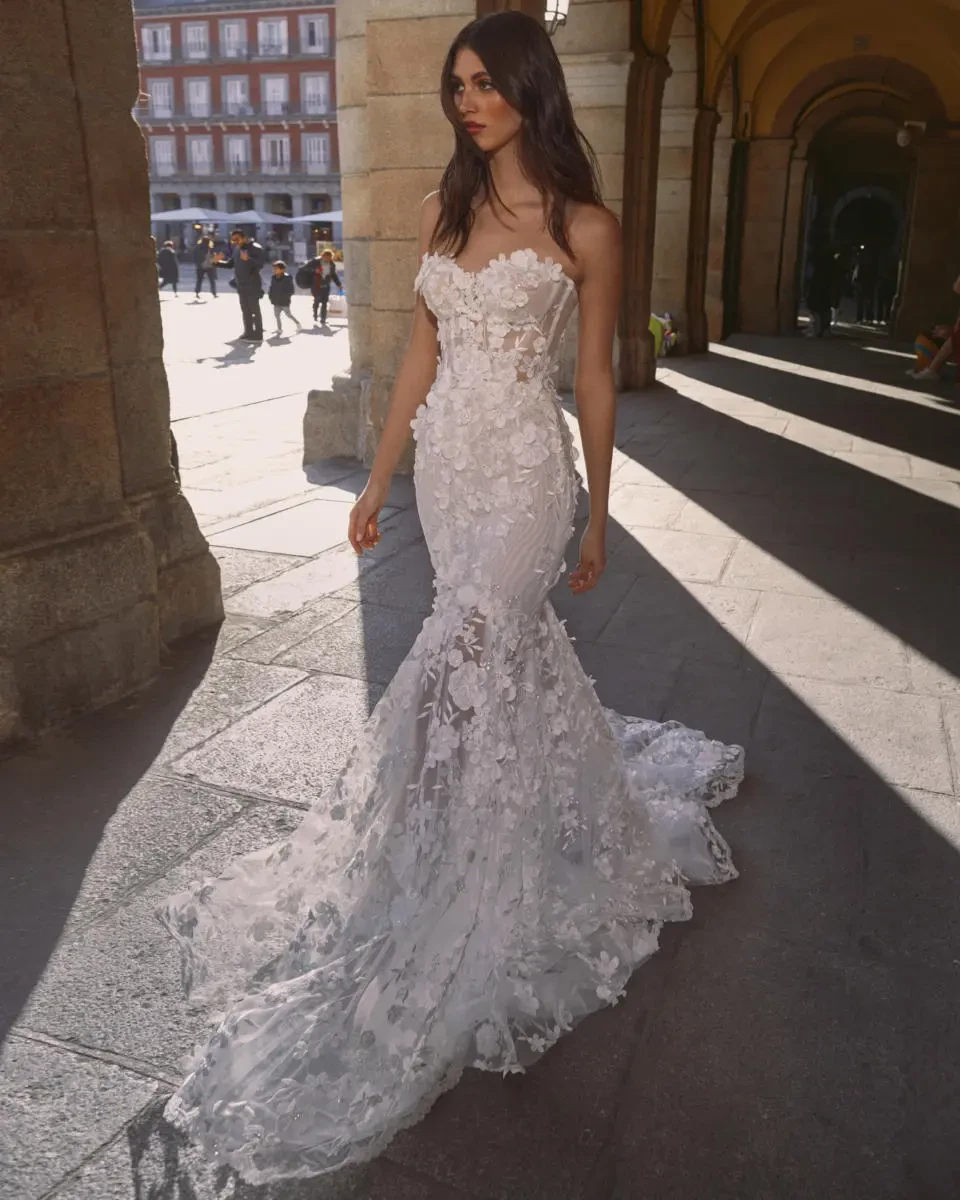 A model wears the Galia Lahav Carrie dress while walking near a courtyard