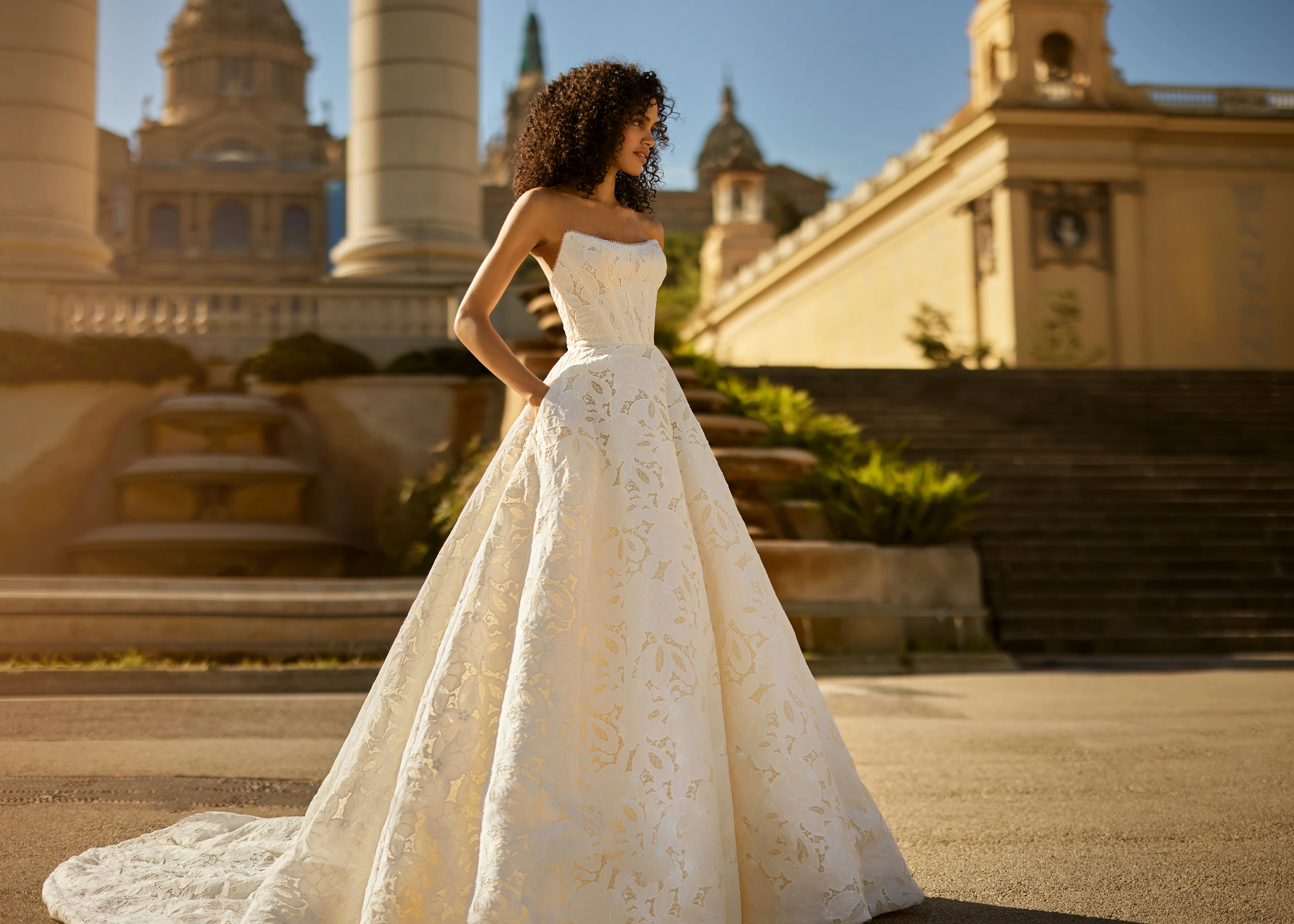 A model wears the Aria dress by Ines Di Santo near a large stone building