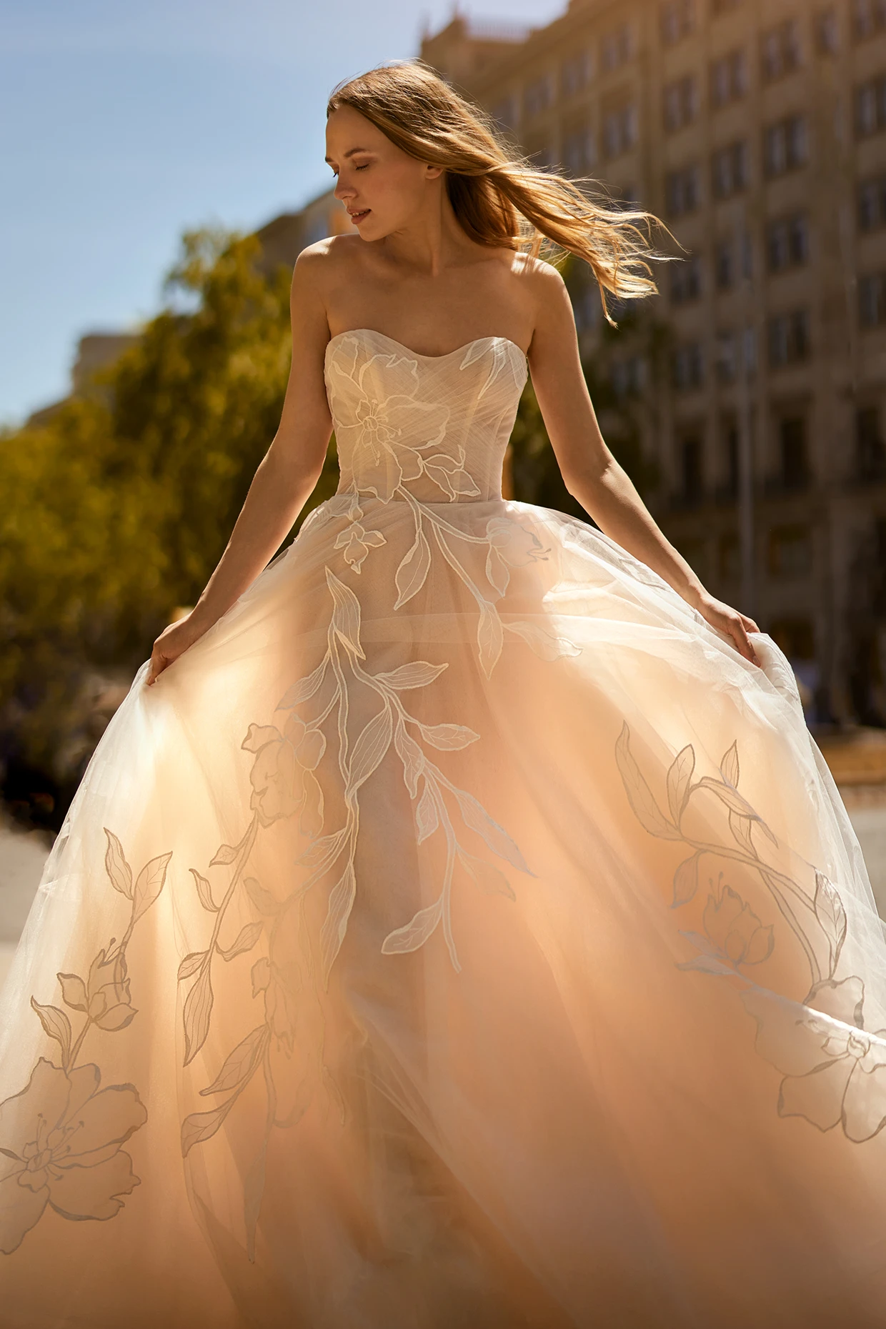 A model wears the Ines Di Santo Rondo dress near a stone building