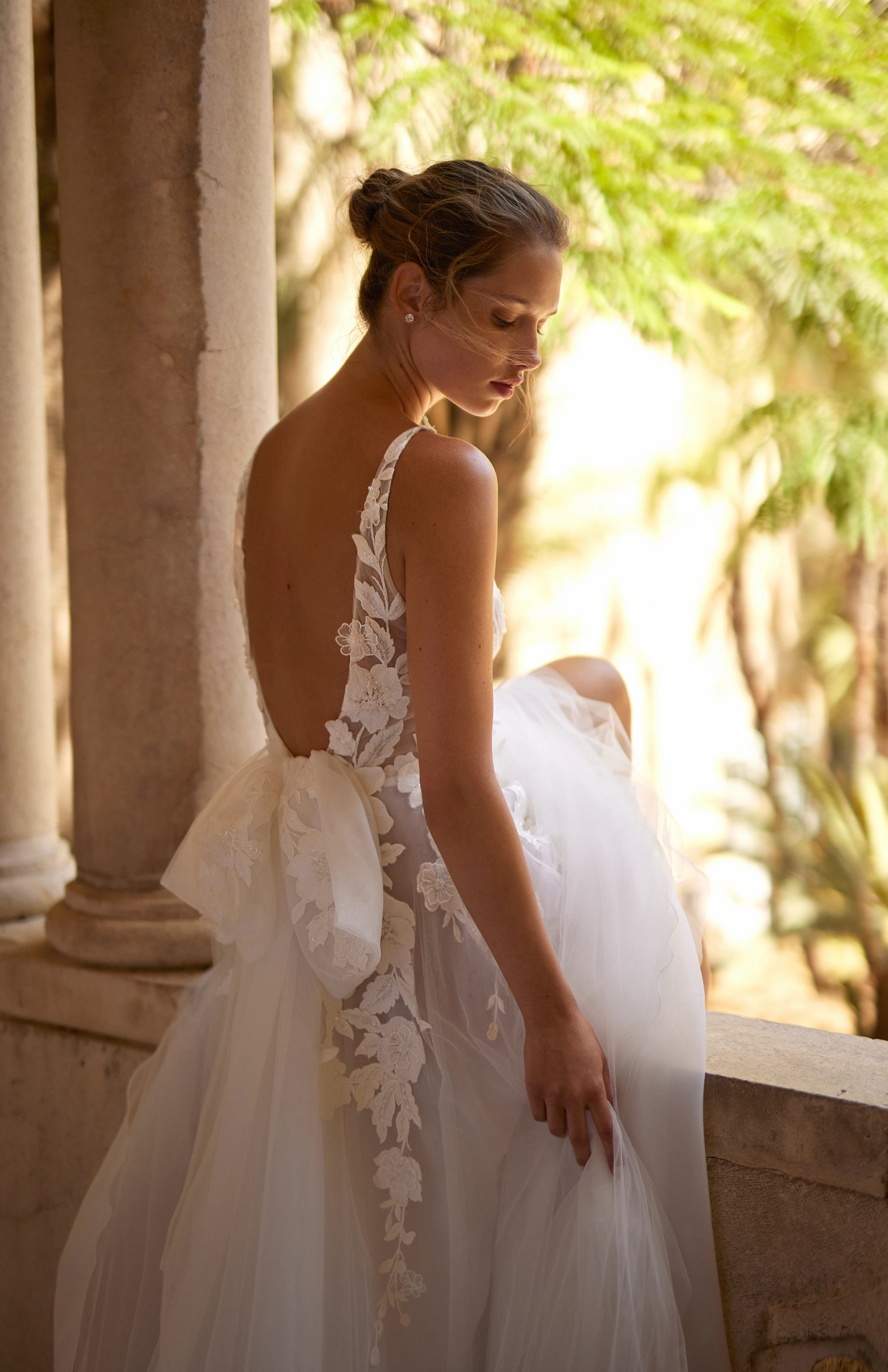 A model wears the Arava Polak Ambre dress on a stone balcony