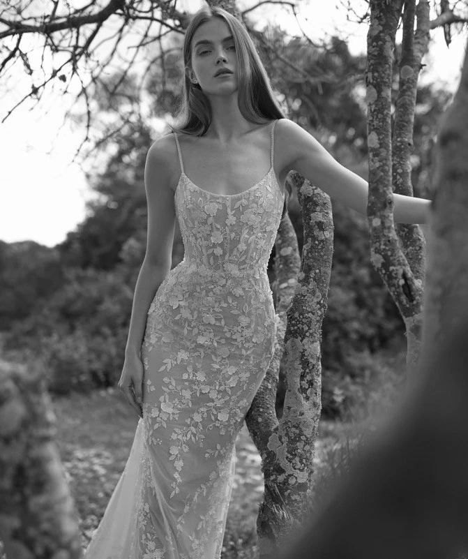 A model wears the Arava Polak Laurel dress while standing in front of a tree