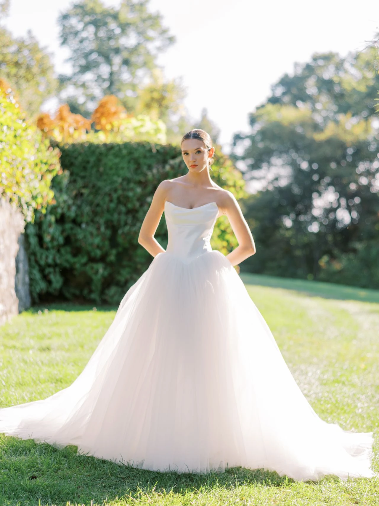 A model wears the Atelier Beccar Cassel dress on a green lawn