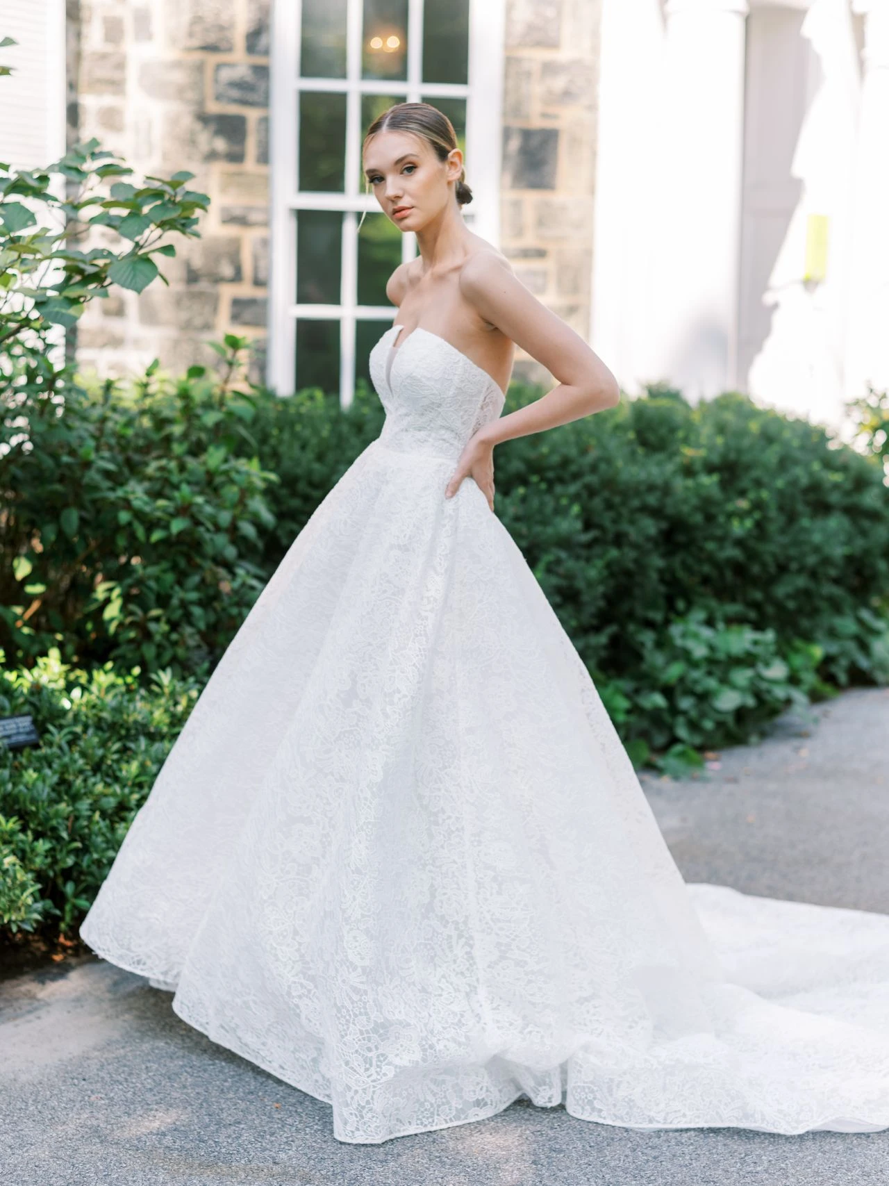 A model wears the Atelier Beccar Chapelle dress near the entrance to a mansion