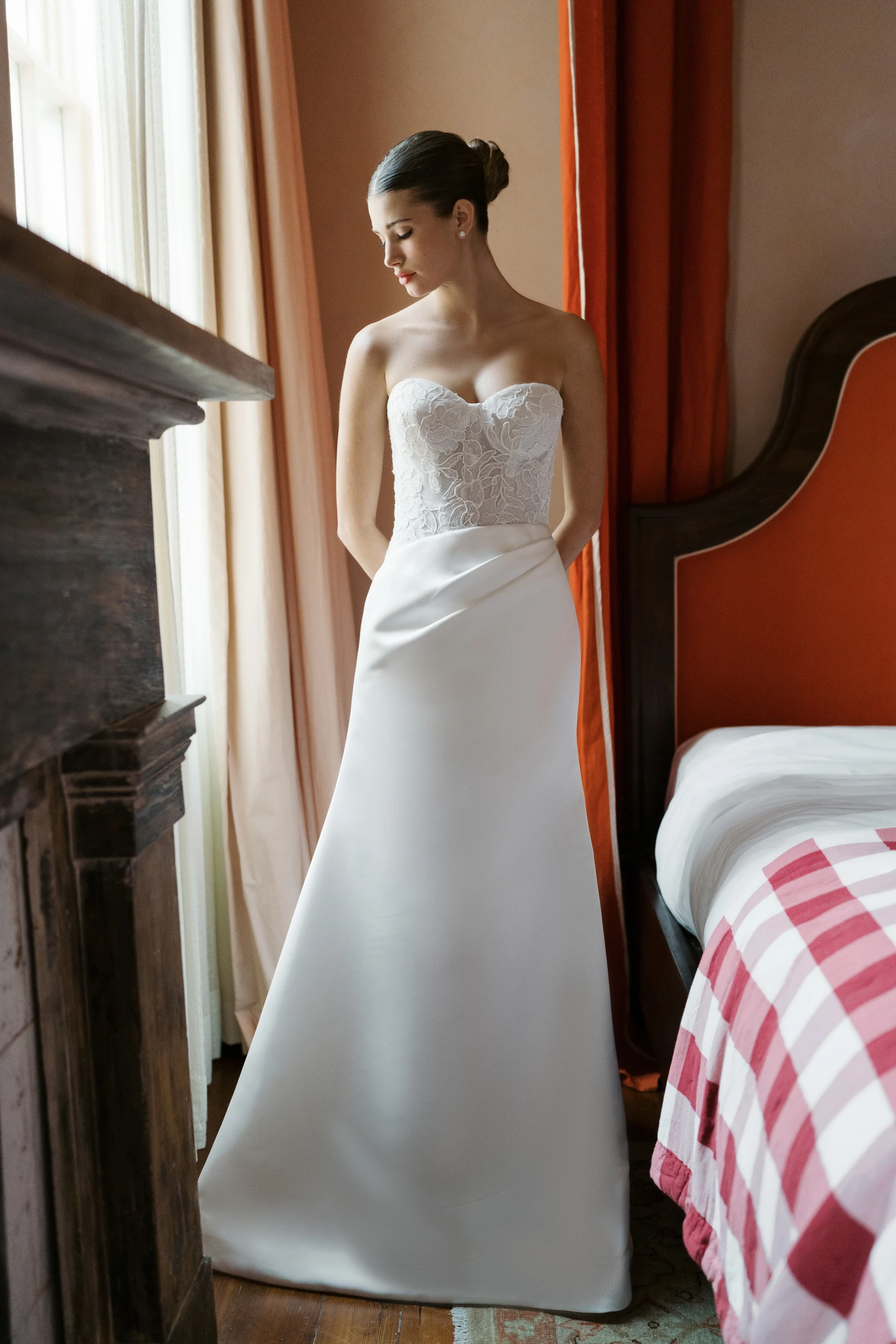 A model wears the Anne Barge Sully dress while standing next to a window in a bedroom