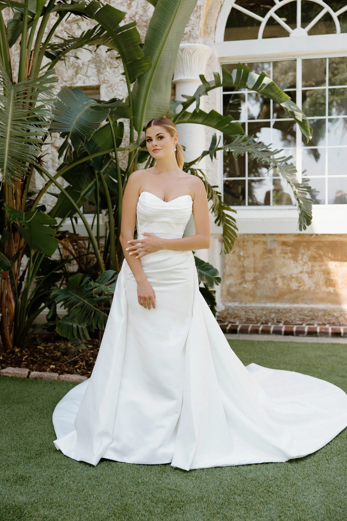 A model wears the Angel Rivera Ayanna dress in the front yard of a mansion