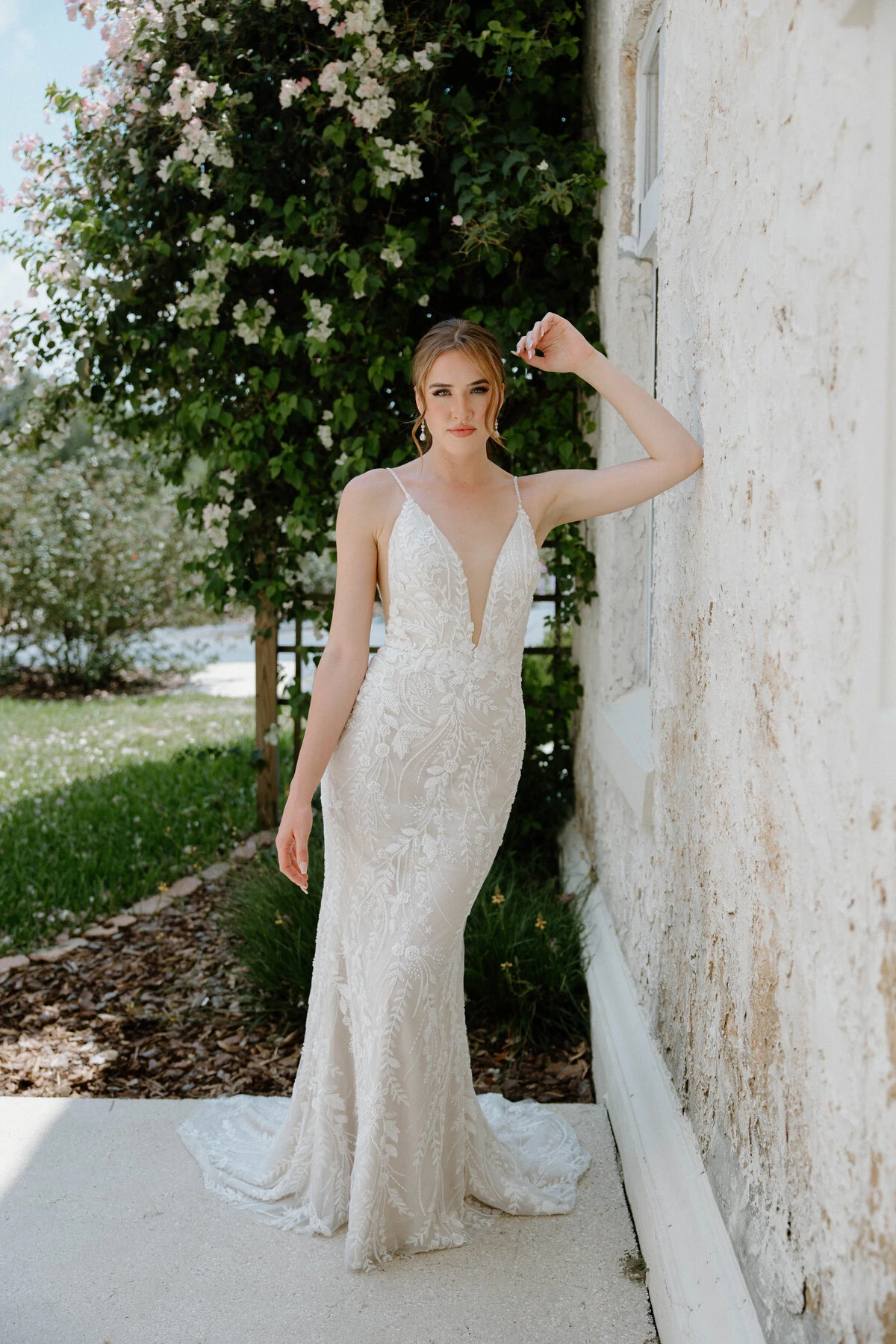 A model wears the Angel Rivera Willow dress while leaning against a wall outside