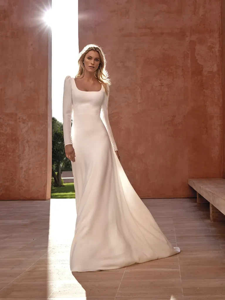 A model wears the Pronovias Aspen dress in a large stone room