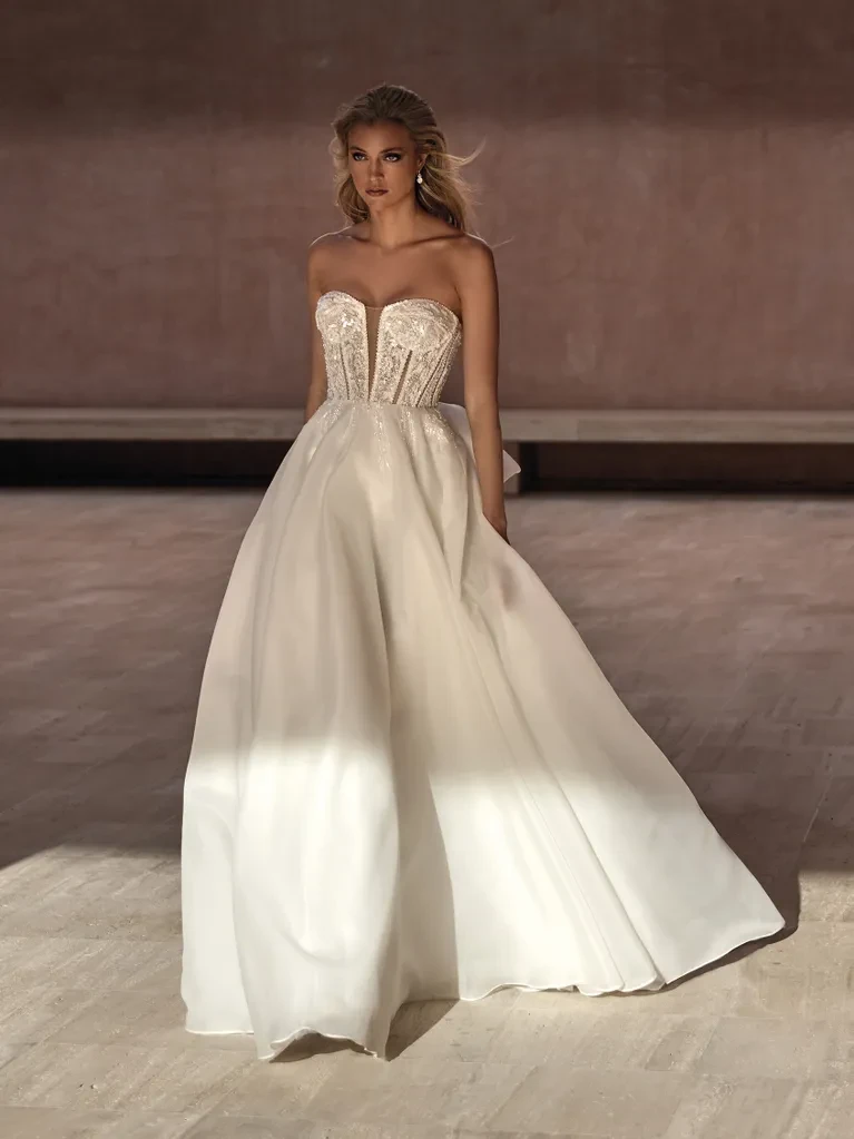 A model wears the Pronovias Bayon dress in a large stone room