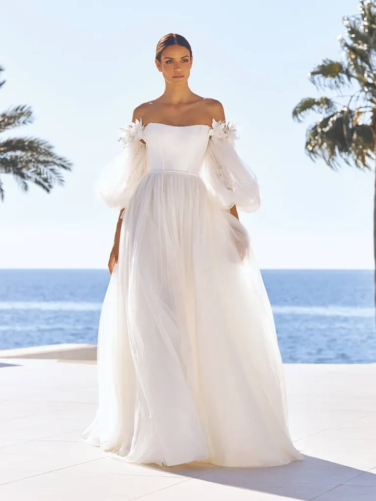 A model wears the Pronovias Rosy dress near the ocean