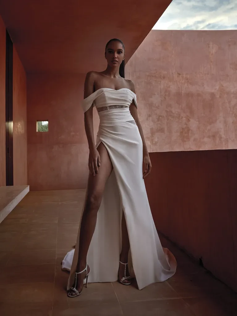 A model wears the Pronovias Sunj dress on a second story balcony